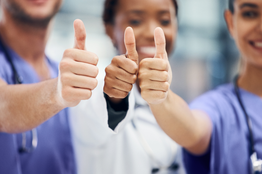 Drei Krankenschwestern zeigen Daumen hoch