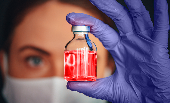 pharmacist holding vial of hazardous drugs