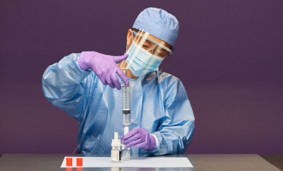 pharmacist compounding syringe unit into vial with vial adaptor